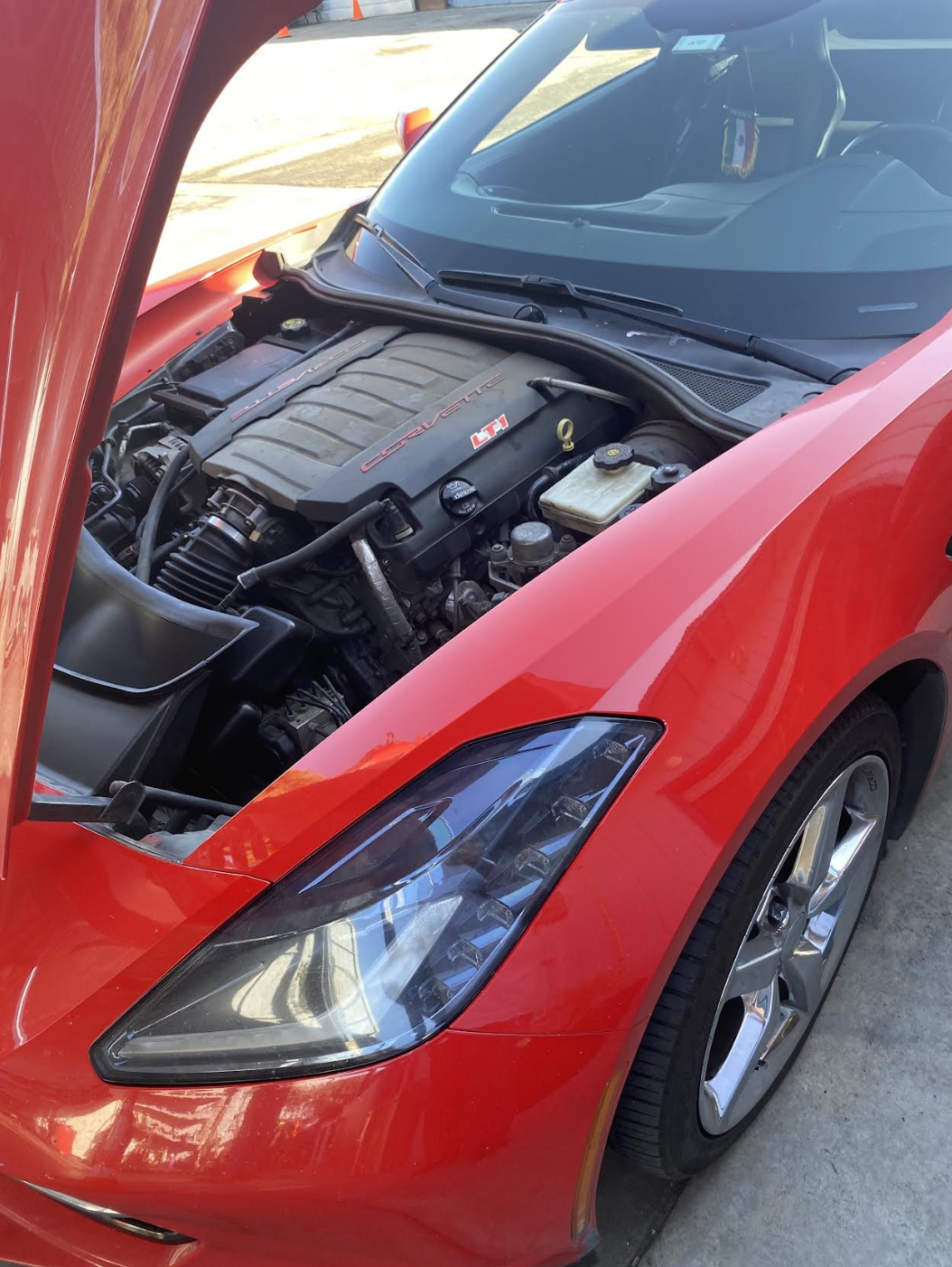 Open hood of a red Corvette showing the LT1 engine