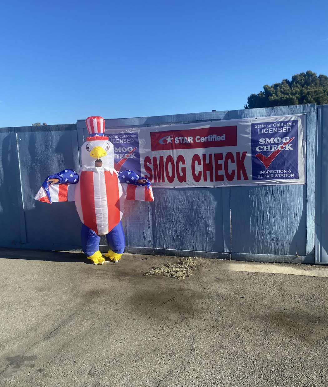Person in an American eagle costume in front of the STAR Certified SMOG CHECK banner