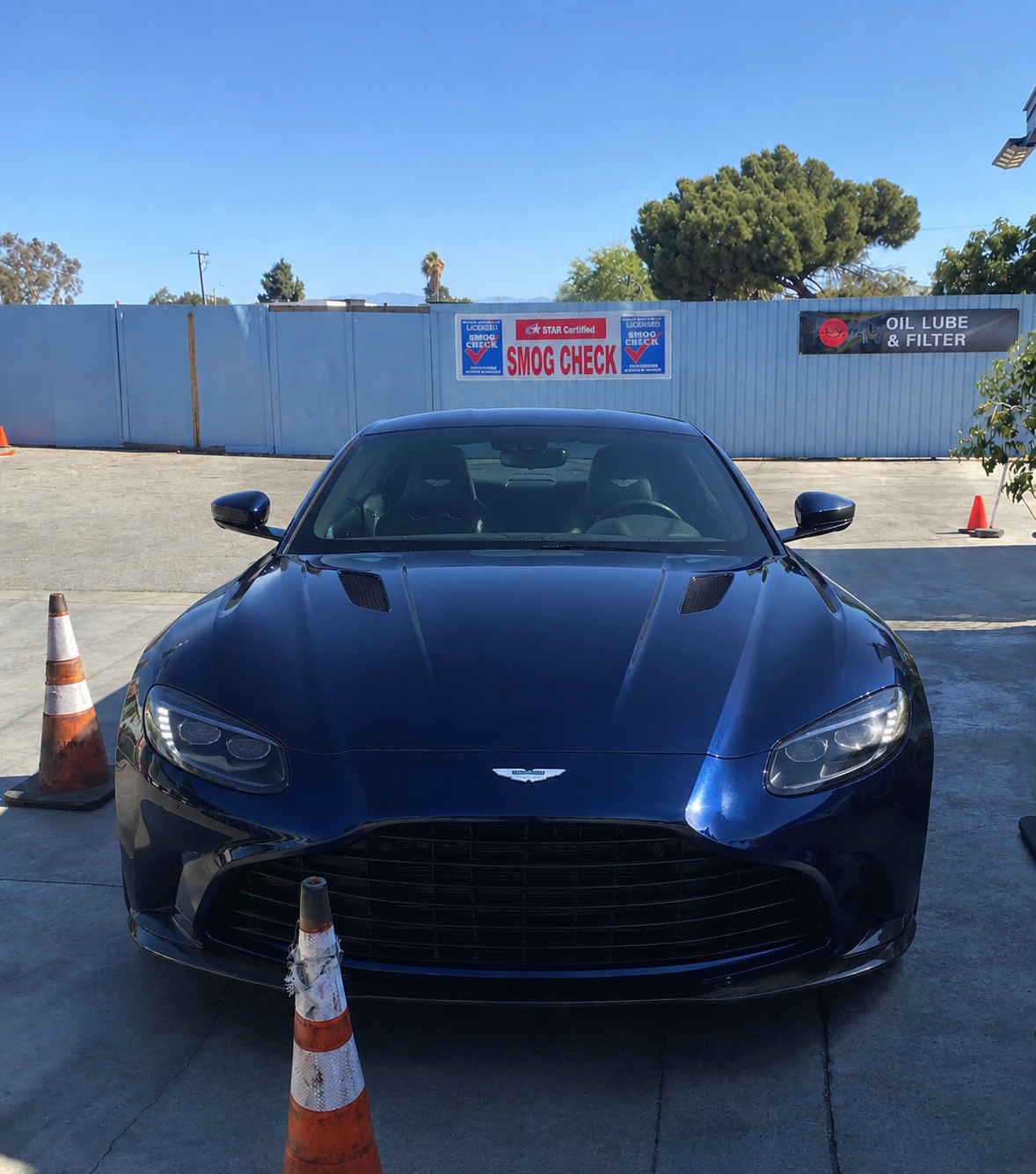 Dark blue luxury sports car between traffic cones at the STAR Certified smog check