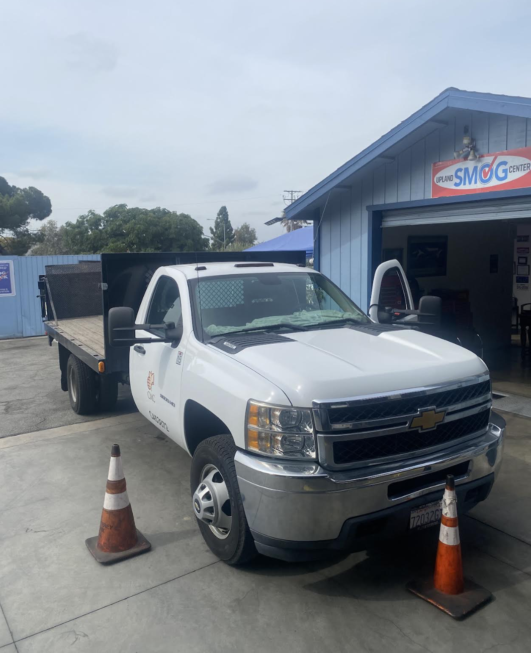 White Chevrolet 3500 HD flatbed truck at Upland Smog Center